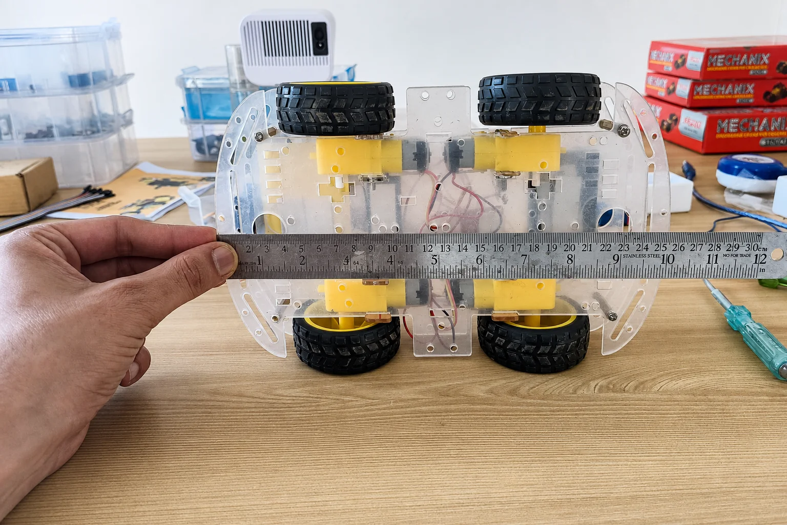 A Makerhood rover being measured with a steel ruler during a rebuild